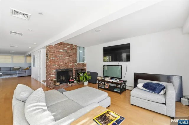 a living room with furniture a fireplace and a flat screen tv