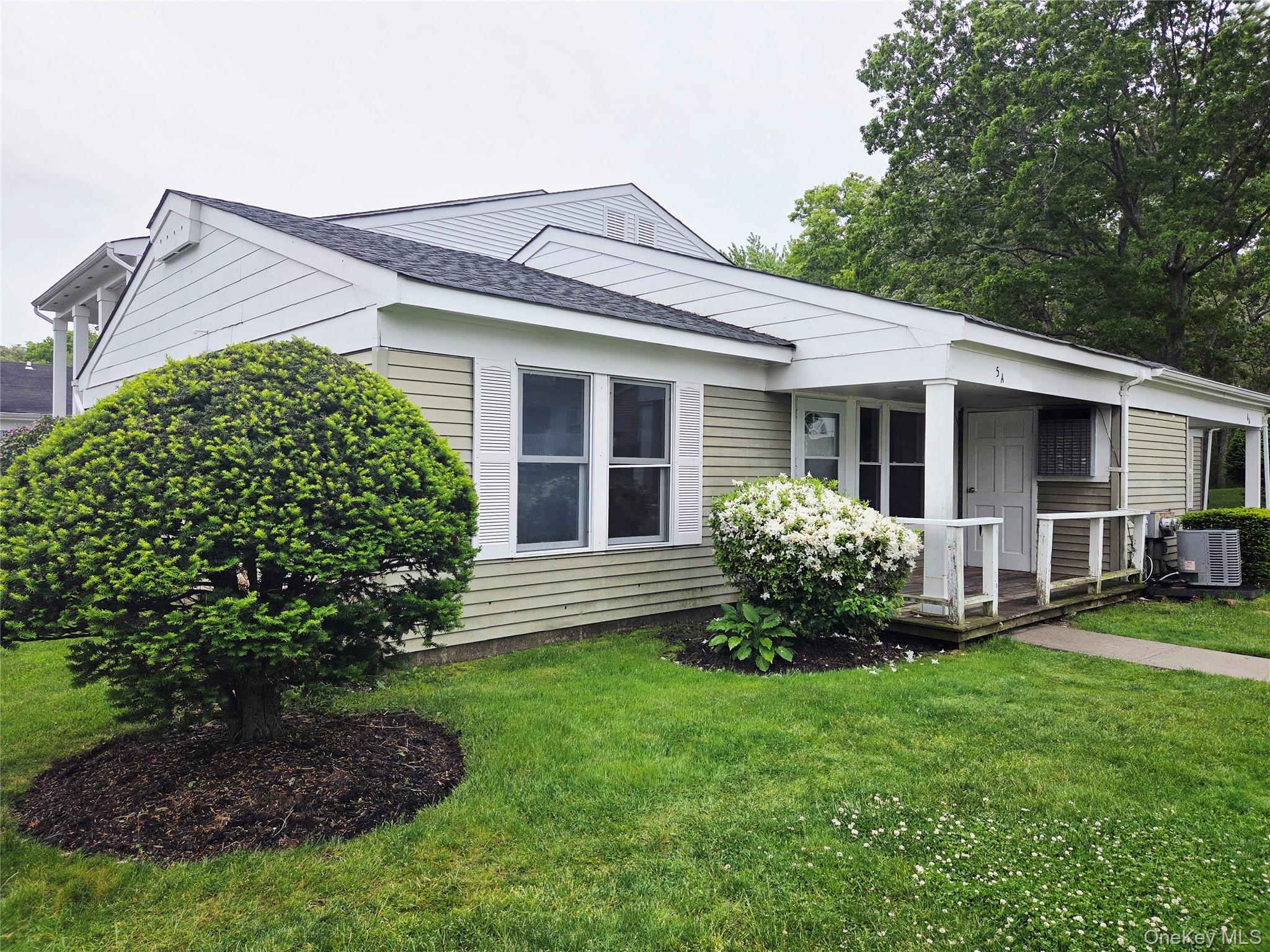 5 Independence Court, Unit 5A Ridge, NY 11961 - Photo 9 of 9 a view of a house with a yard and plants