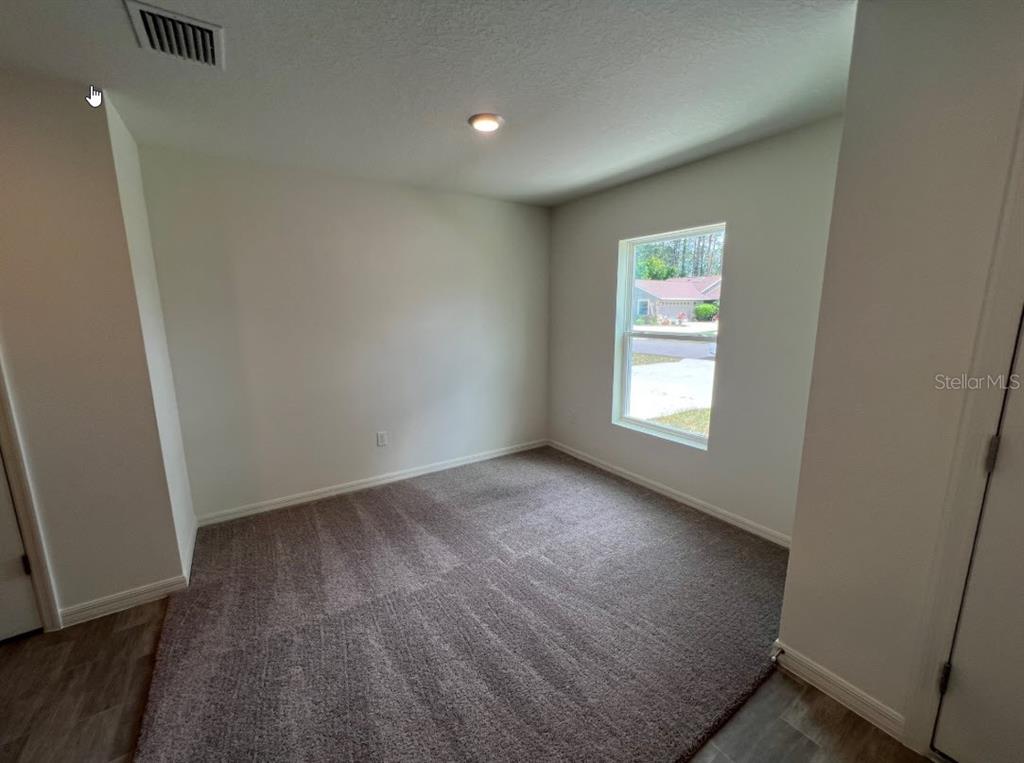 25 Ryding Lane Palm Coast, FL 32164 - Photo 3 of 13 an empty room with wooden floor and windows
