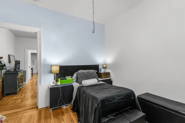 a bedroom with a bed and wooden floor