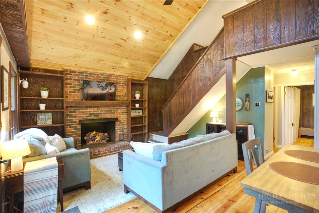 9440 Blackberry Road Lenoir, NC 28645 - Photo 6 of 30 a living room with furniture a fireplace and a flat screen tv