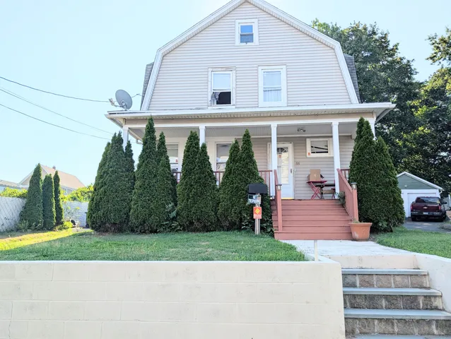 a front view of a house with a yard and trees