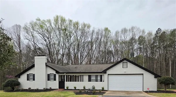 a front view of a house with a yard and trees