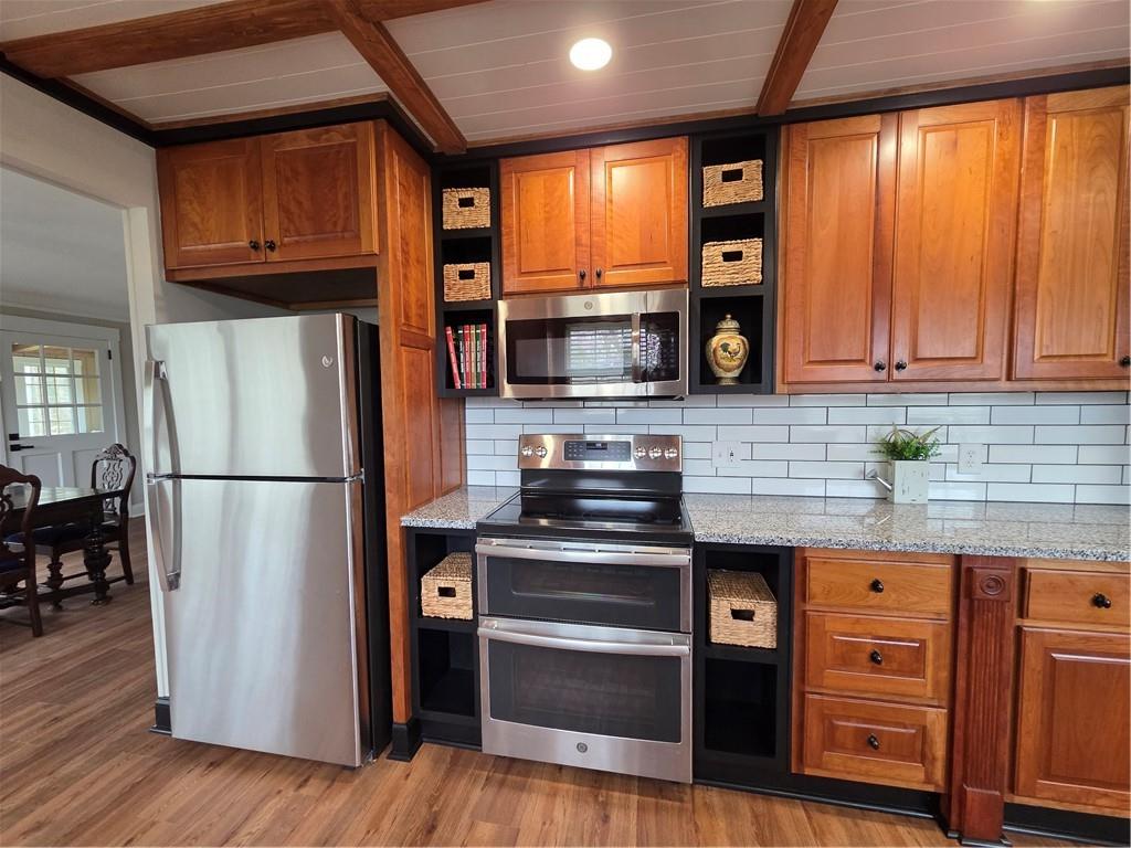 1012 Highway 332 Pendergrass, GA 30567 - Photo 14 of 51 a kitchen with granite countertop wooden floors stainless steel appliances and a window