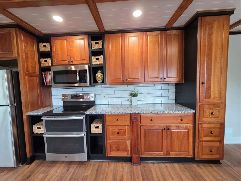 1012 Highway 332 Pendergrass, GA 30567 - Photo 15 of 51 a kitchen with stainless steel appliances granite countertop wooden cabinets a stove and a refrigerator