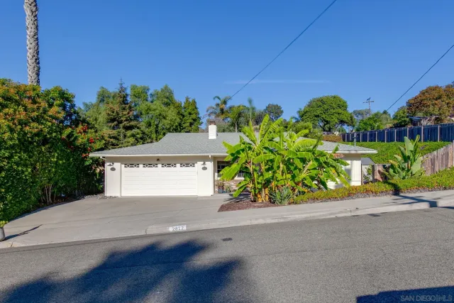 a front view of a house with a yard and street