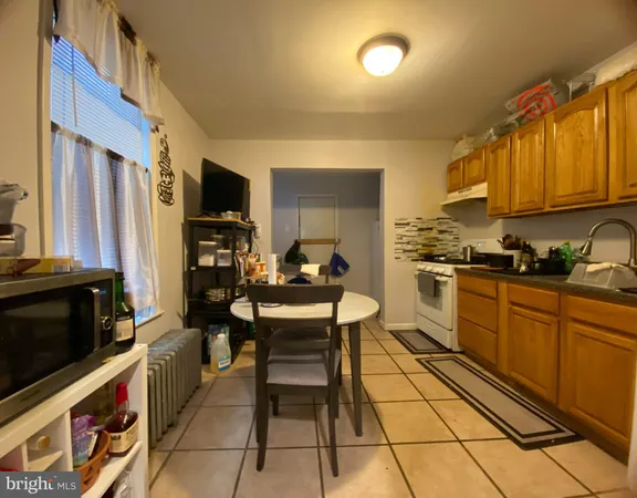 a kitchen with stainless steel appliances kitchen island granite countertop a refrigerator and a stove top oven