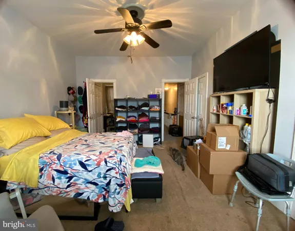 a bedroom with bed and a flat tv screen on the dresser