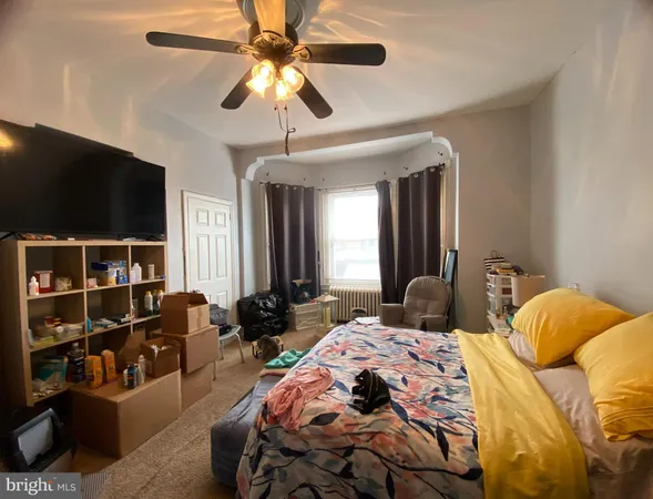 a bedroom with a bed a flat screen tv and a chandelier