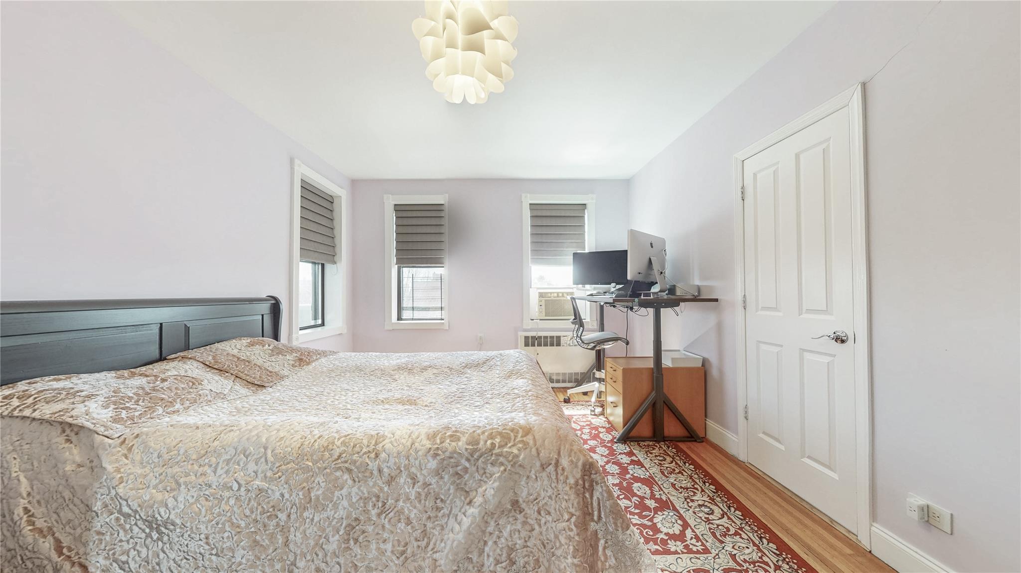 143-50 Hoover Avenue, Unit 507 Queens, NY 11435 - Photo 15 of 24 Bedroom featuring baseboards, wood finished floors, and radiator heating unit
