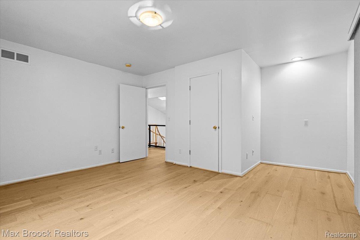 1830 Lone Pine Road Bloomfield Hills, MI 48302 - Photo 42 of 70 Wood-finish flooring throughout, white walls, and a built-in closet with a solid door