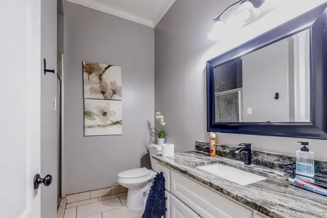 a bathroom with a granite countertop toilet sink and mirror