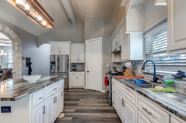 a kitchen with stainless steel appliances granite countertop a sink stove and refrigerator