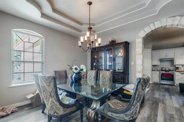 a dining room with furniture a chandelier and wooden floor
