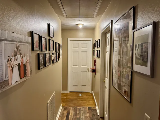 a view of a hallway with closet and a bathroom