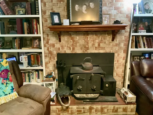 a living room with fireplace furniture and a book shelf