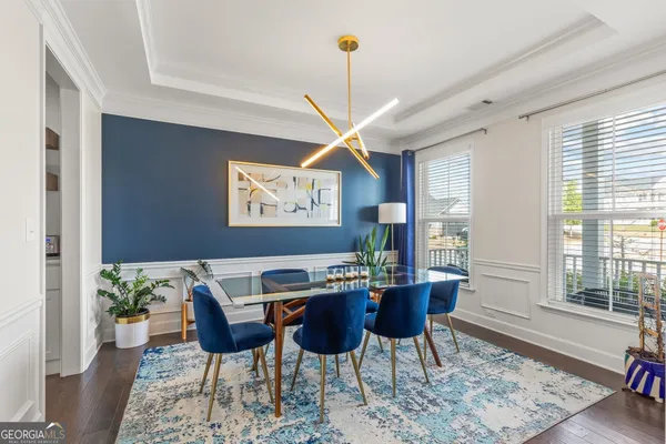 a kitchen with stainless steel appliances kitchen island granite countertop a table chairs sink and cabinets