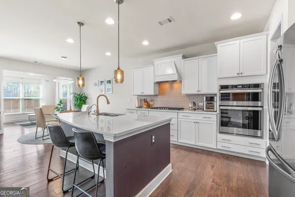 a kitchen with stainless steel appliances kitchen island granite countertop a refrigerator and a stove top oven