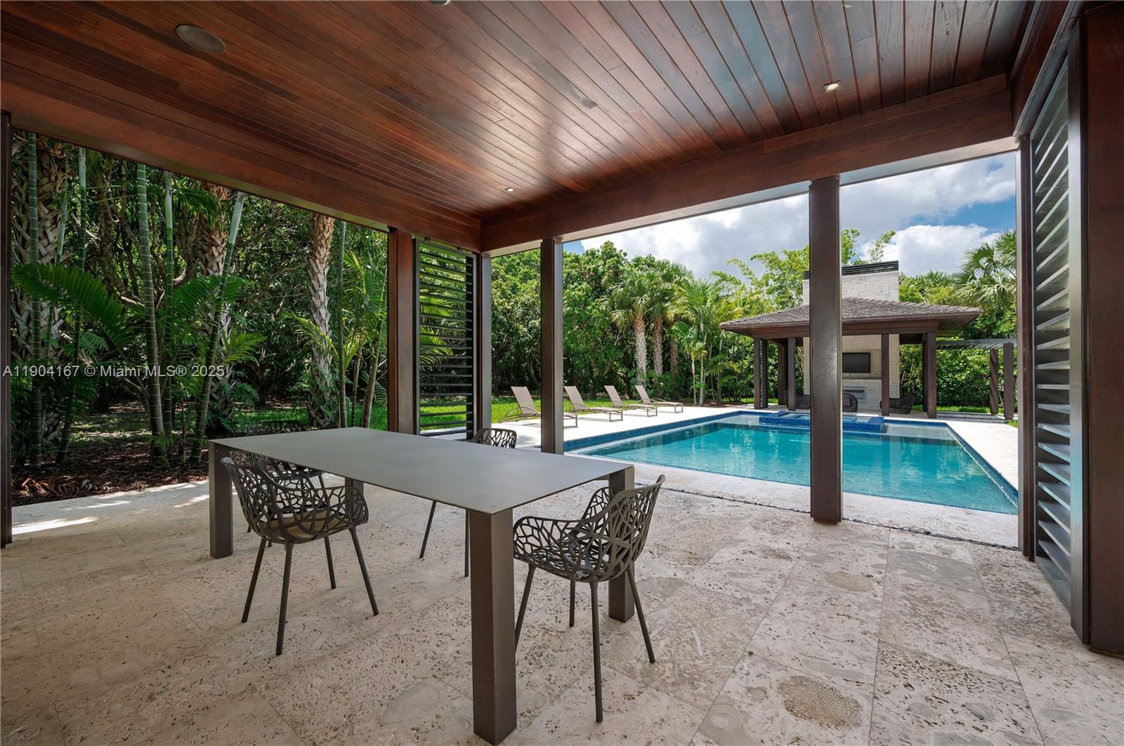 9000 Southwest 63rd Court Pinecrest, FL 33156 - Photo 21 of 36 a patio with yard glass top table and chairs