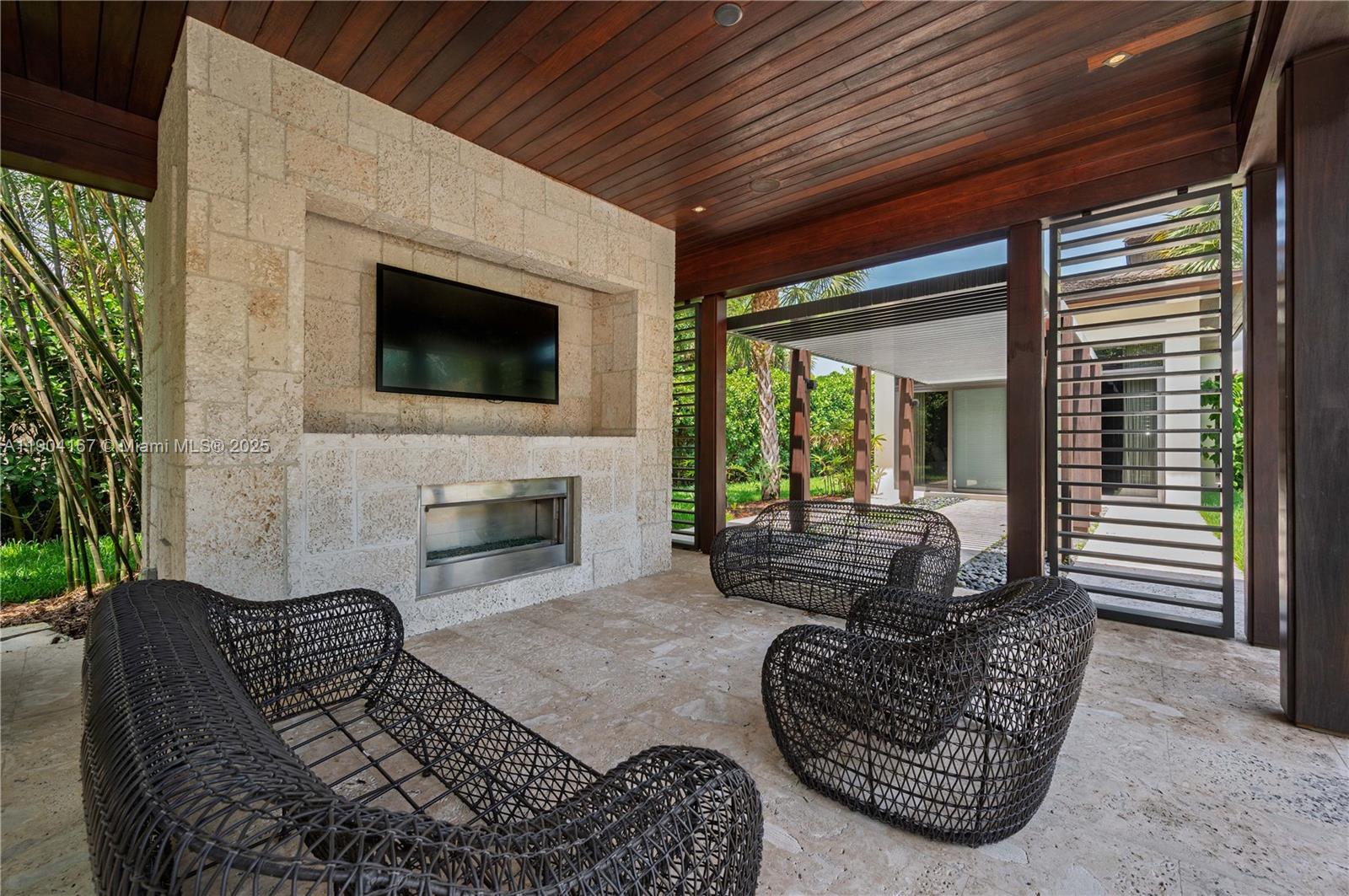 9000 Southwest 63rd Court Pinecrest, FL 33156 - Photo 26 of 36 a living room with furniture a fireplace and a flat screen tv