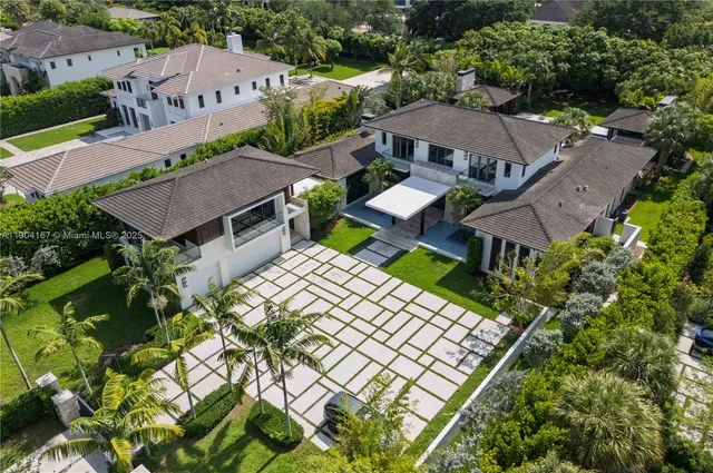 an aerial view of a house with swimming pool and outdoor seating