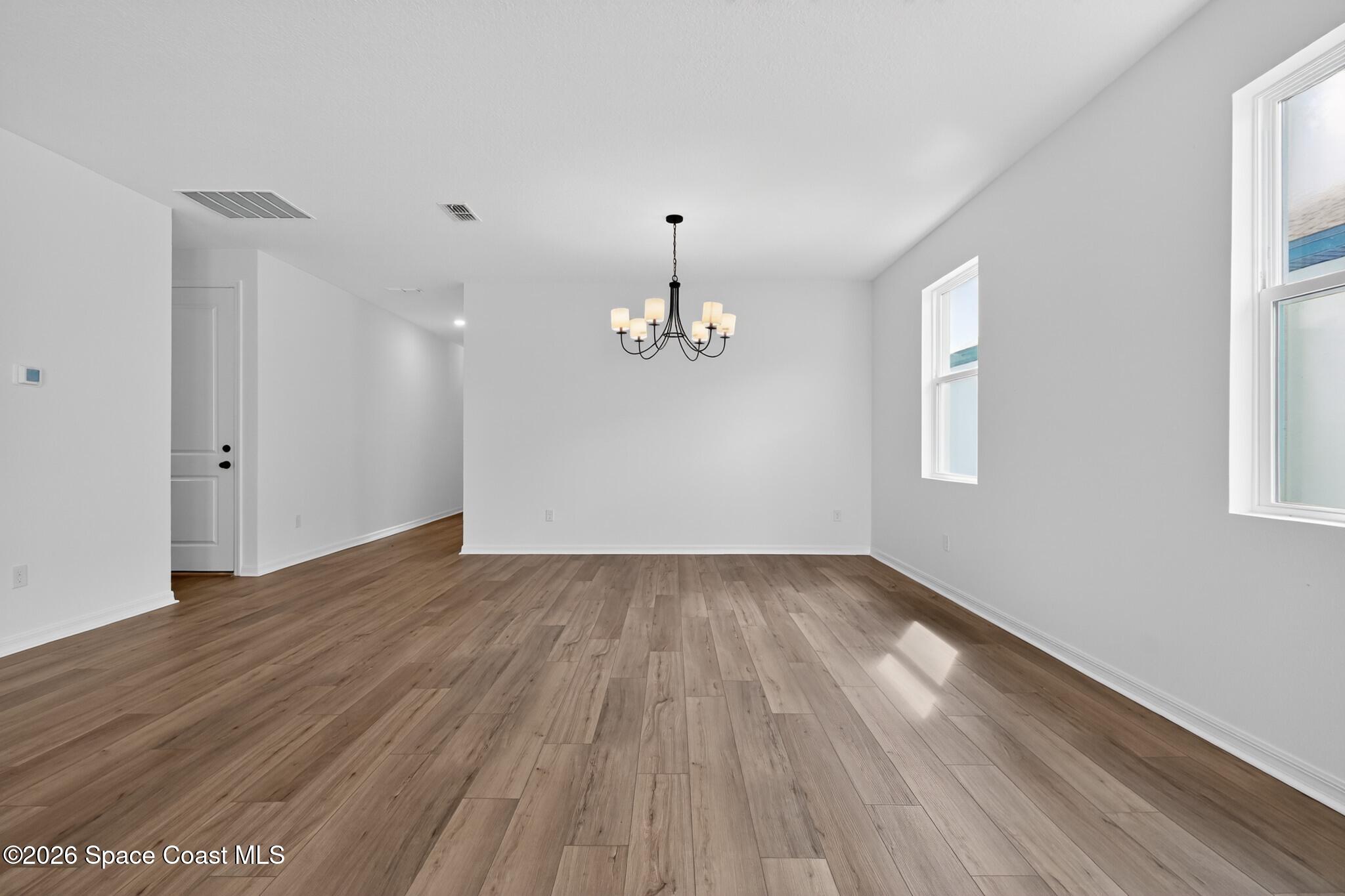 4372 Dockyard Drive Rockledge, FL 32955 - Photo 5 of 24 wooden floor in an empty room with a window