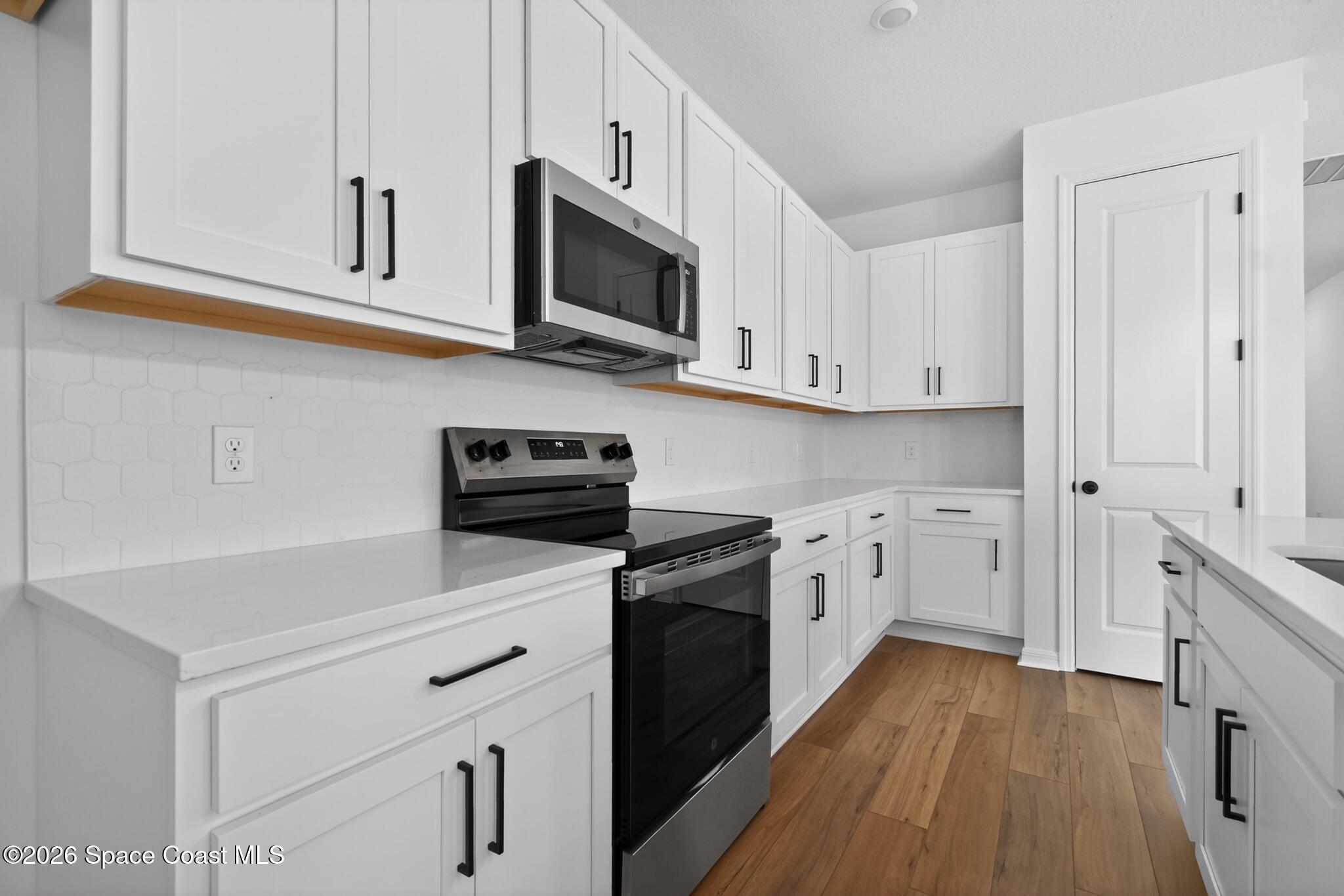 4372 Dockyard Drive Rockledge, FL 32955 - Photo 7 of 24 a kitchen with white cabinets stainless steel appliances and sink