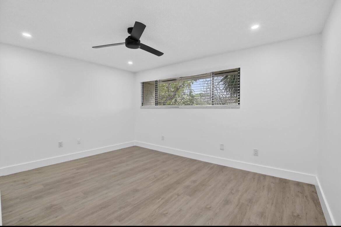 373 Northwest 94th Terrace Plantation, FL 33324 - Photo 2 of 10 an empty room with wooden floor ceiling fan and window