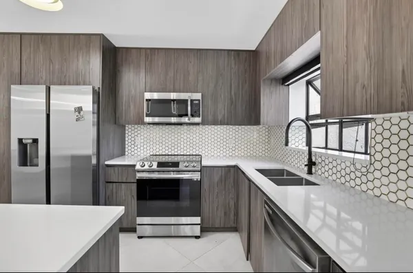 a kitchen with stainless steel appliances granite countertop a sink stove and refrigerator