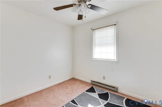 an empty room with windows and ceiling fan