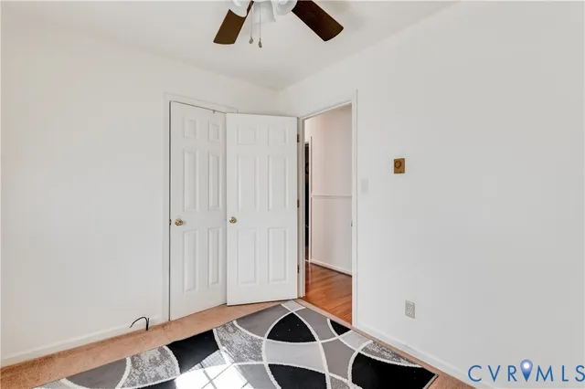 an empty room with a window and a ceiling fan