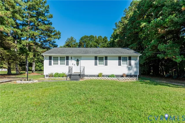 a front view of house with a garden and trees