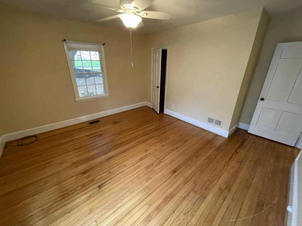 200 East Drewry Lane Raleigh, NC 27609 - Photo 15 of 22 a view of an empty room with wooden floor and a window