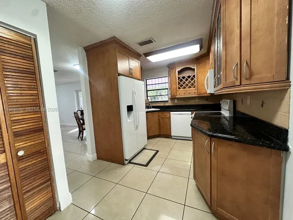 a kitchen with a refrigerator and a stove top oven