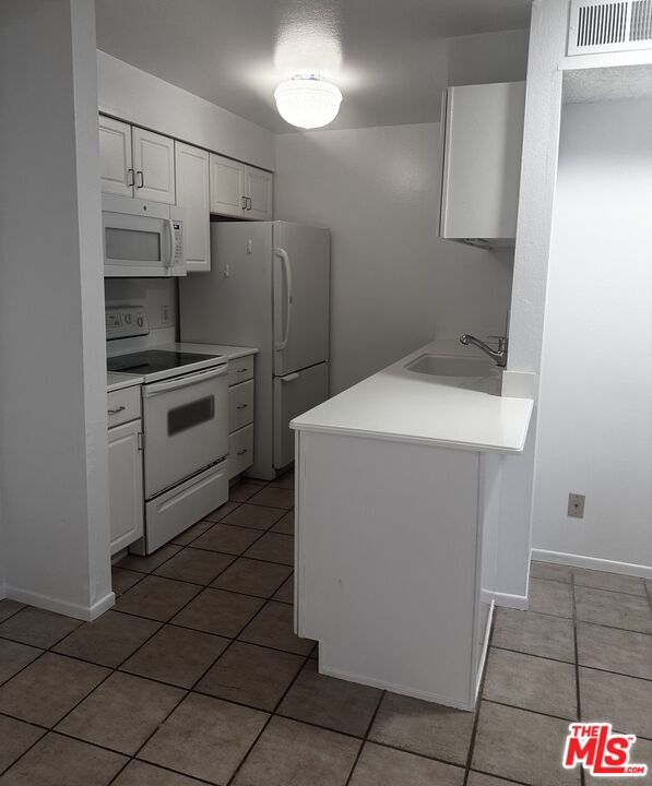 1119 Raintree Circle Culver City, CA 90230 - Photo 3 of 13 a kitchen with a sink cabinets and stainless steel appliances