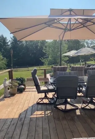 a view of a roof deck with table and chairs under an umbrella
