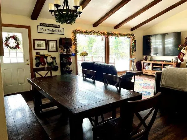 a living room with stainless steel appliances furniture a rug and a large window
