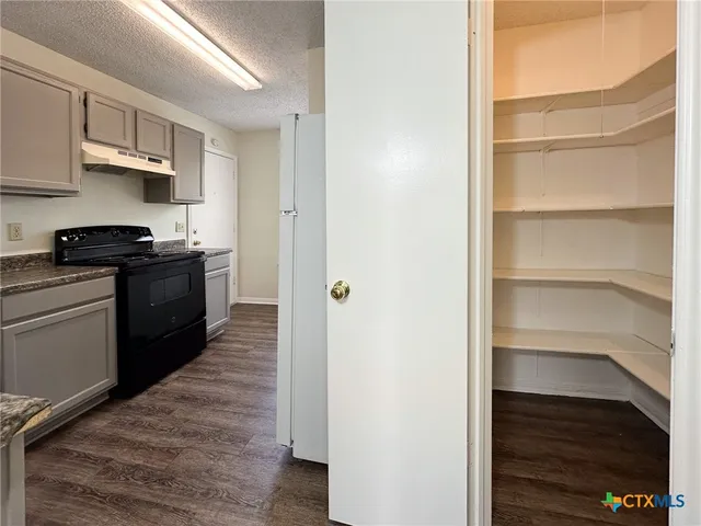 a view of a kitchen from the hallway with a stove