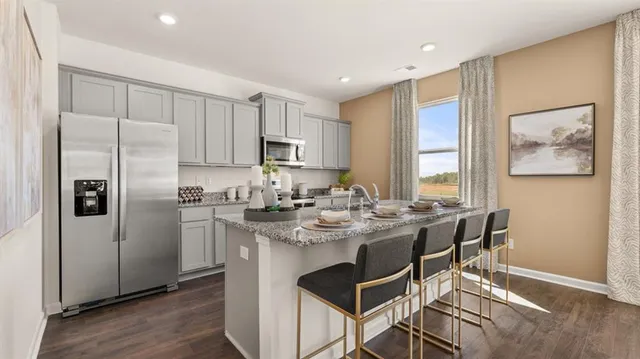 a kitchen with stainless steel appliances granite countertop a refrigerator and a stove top oven