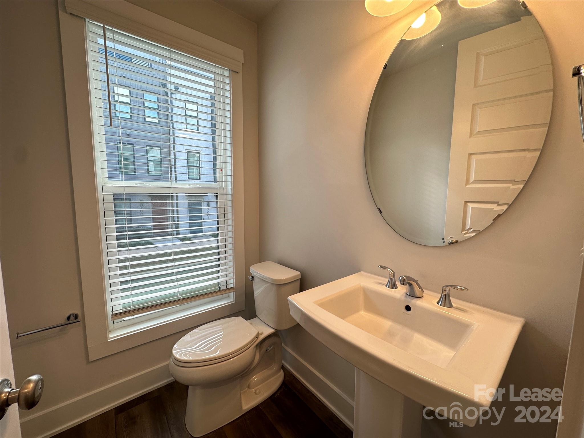 2124 Terwilliger Trail Charlotte, NC 28203 - Photo 13 of 36 a bathroom with a sink a toilet and a mirror