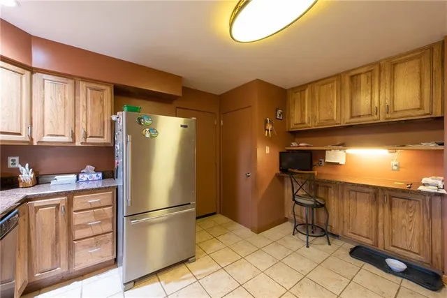 a kitchen with stainless steel appliances granite countertop a refrigerator a stove a sink and a cabinets