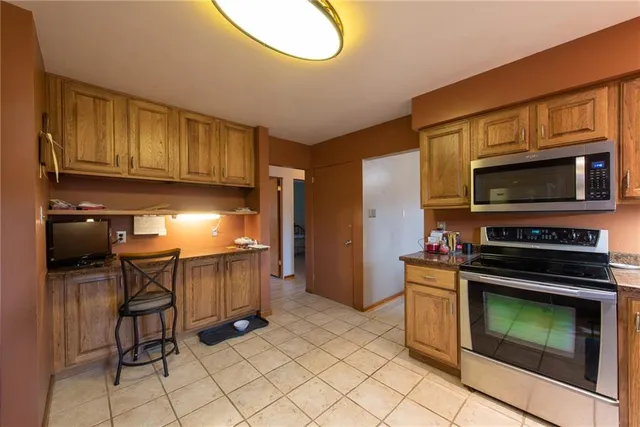 a kitchen with granite countertop a stove top oven microwave and cabinets