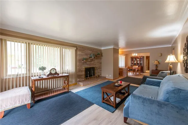 a living room with furniture a fireplace and a large window