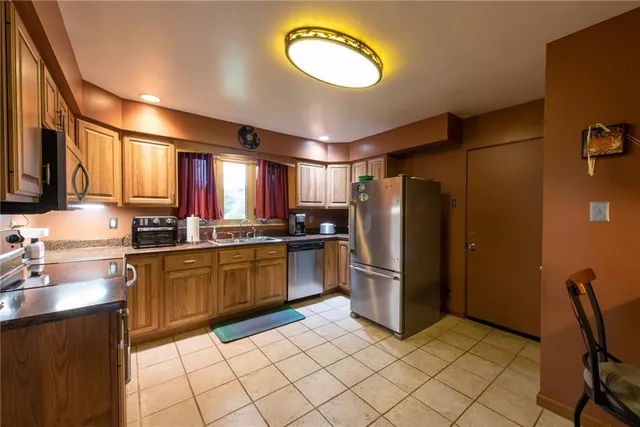 a kitchen with refrigerator and chairs