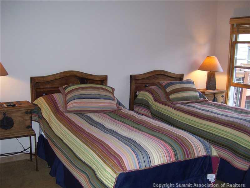 195 River Run Road, Unit 8012 Keystone, CO 80435 - Photo 11 of 19 a bedroom with two beds and a lamp on dresser