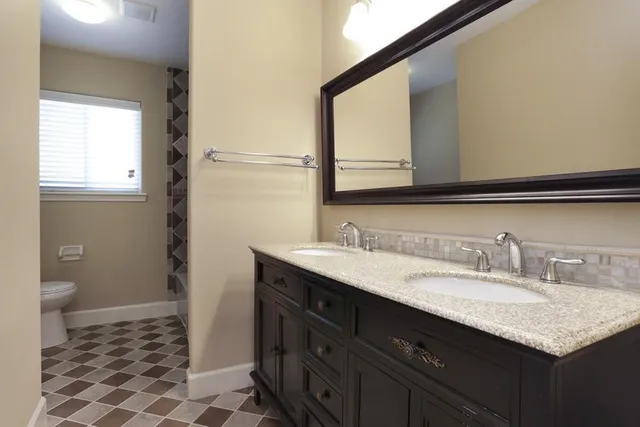 a bathroom with a granite countertop sink and a mirror
