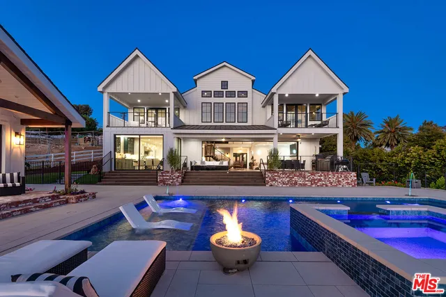 a living room with furniture a chandelier and a fireplace