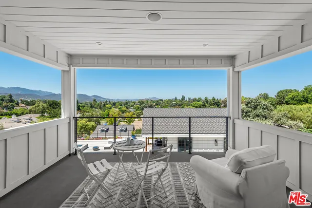 a view of a patio with couches chairs potted plants and ocean view