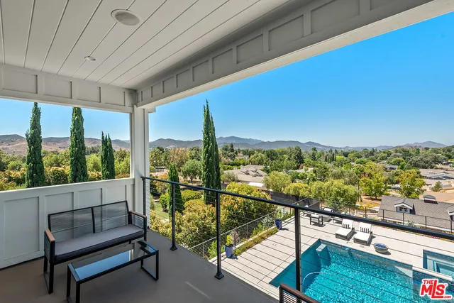 a view of a city from a balcony with furniture