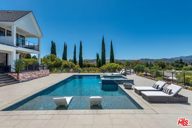 a view of swimming pool with outdoor seating and plants